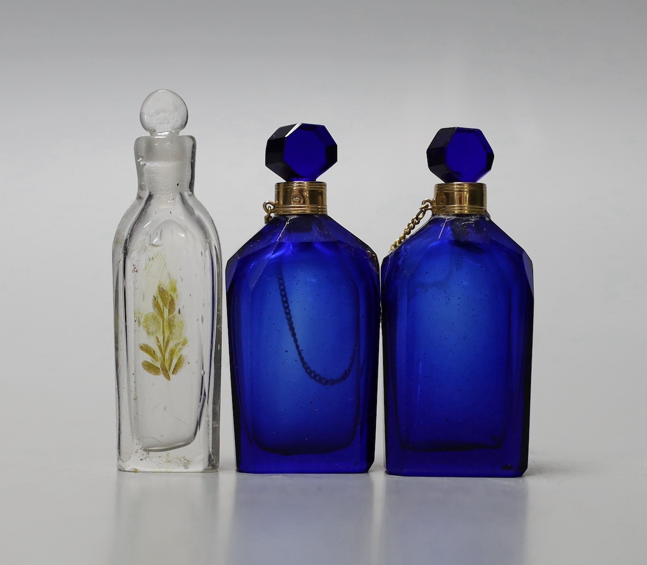 A cased pair of yellow metal mounted blue glass scent bottles and one other case glass scent bottle.
